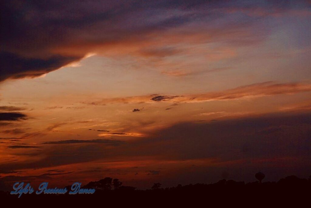 Colorful sunset from balcony, looking back inland over trees at Surfside Beach