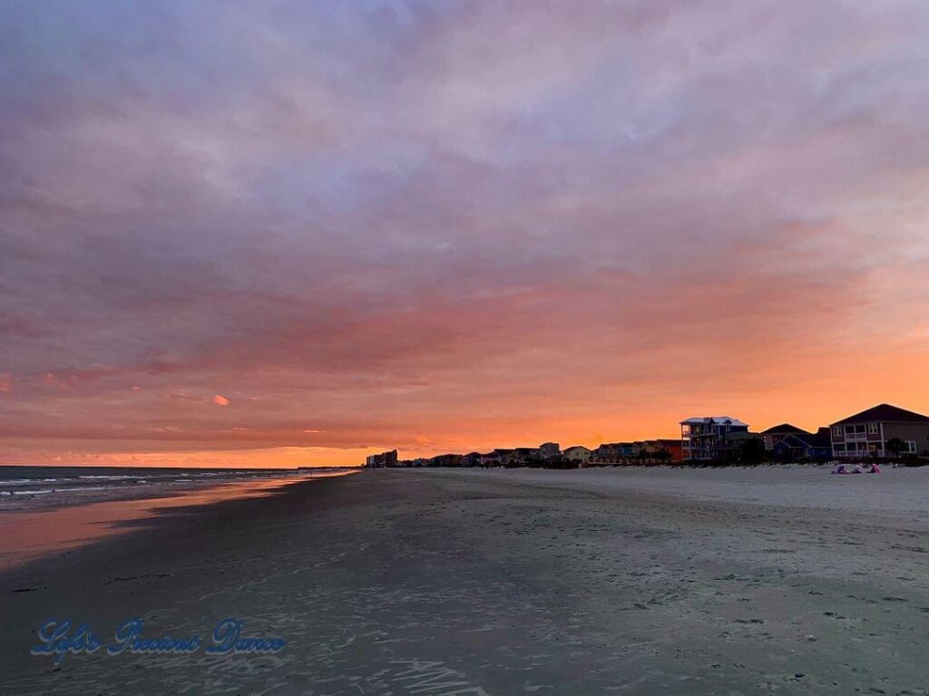 Colorful sunset looking down Surfside Beach, Ocean on the left and condos on the right.