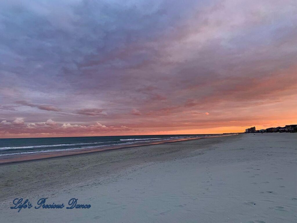 Colorful sunset looking down Surfside Beach, Ocean on the left and condos on the right.