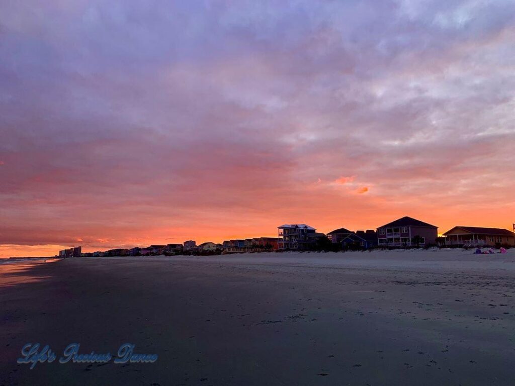 Colorful sunset looking down Surfside Beach, Ocean on the left and condos on the right.