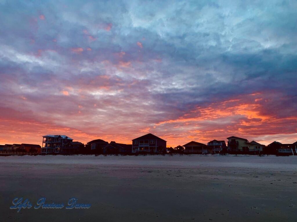 Colorful sunset at Surfside Beach lookin inland over beach and condos.