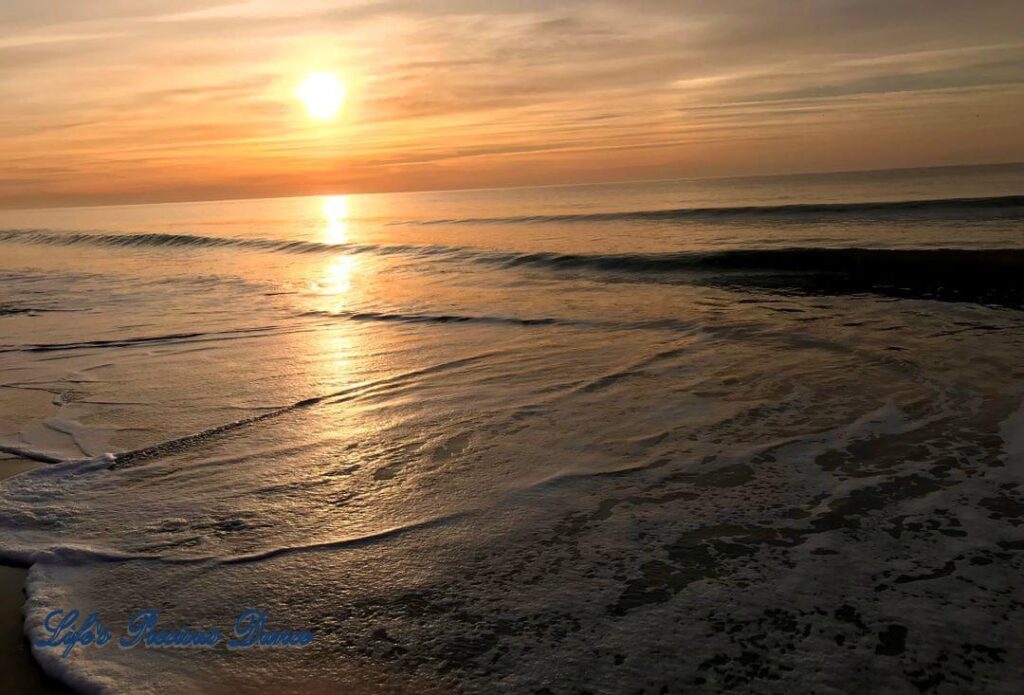 Sunrise reflecting onto the ocean, as waves roll in at Myrtle Beach, South Carolina