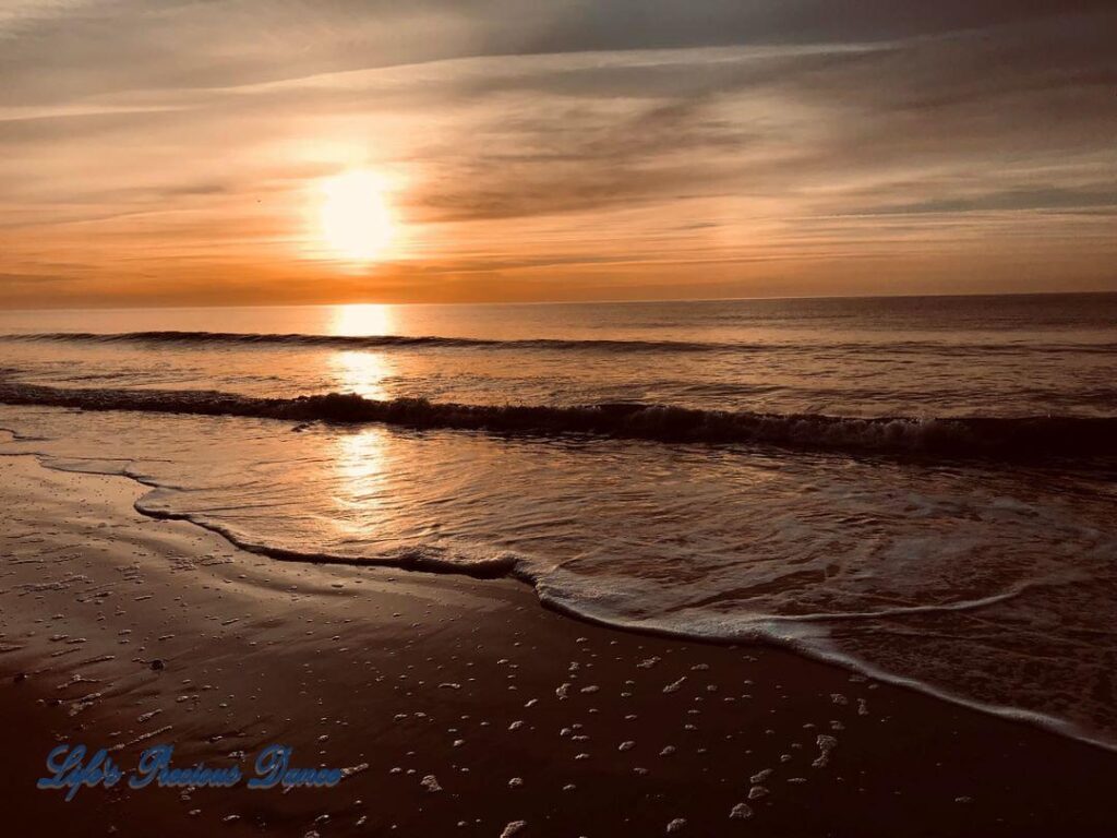 Sunrise reflecting onto the ocean, as waves roll in at Myrtle Beach, South Carolina