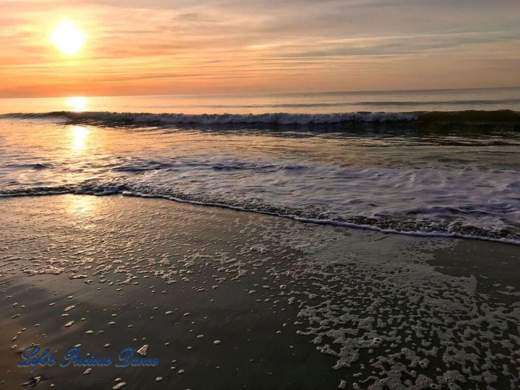 Sunrise reflecting onto the ocean, as waves roll in at Myrtle Beach, South Carolina