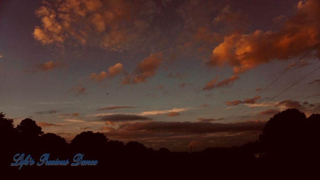 Sunset above a darkened pasture