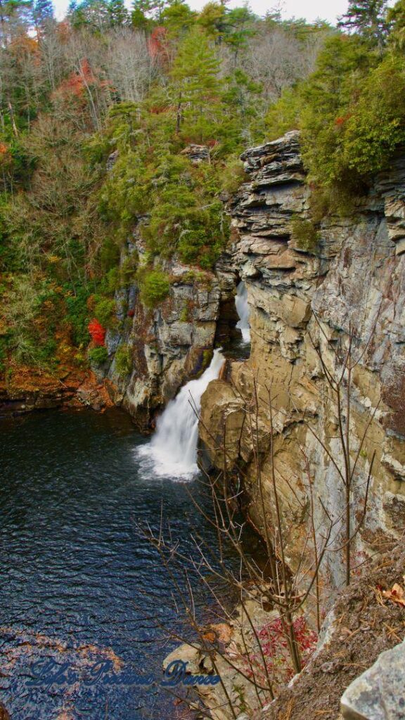 Linville Falls pouring down into the river basin. Colorful trees along the water.