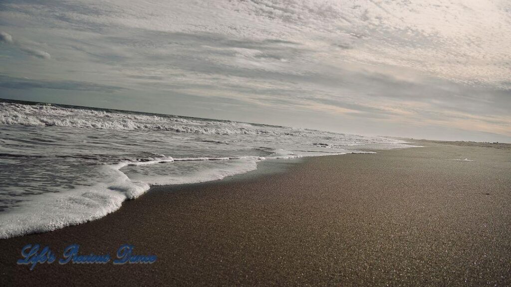 Waves crashing into shore on Pawley&#039;s Island. Clouds above.