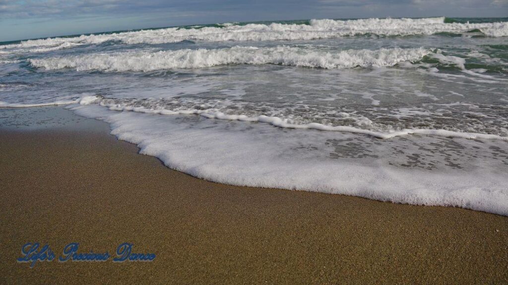 Waves crashing into shore on Pawley&#039;s Island. Clouds above.