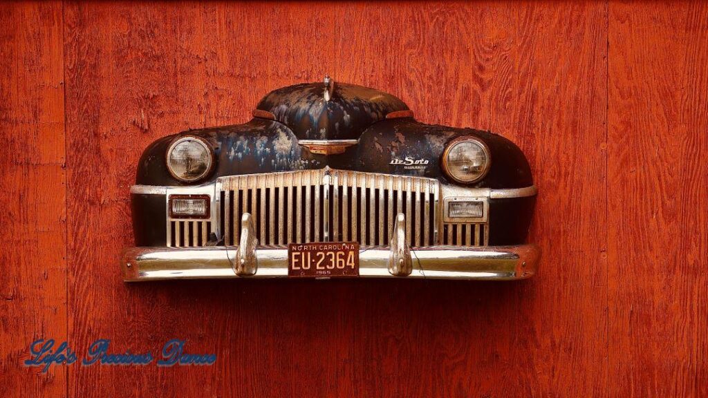 Close up of front end of classic DeSoto affixed to front of barn.