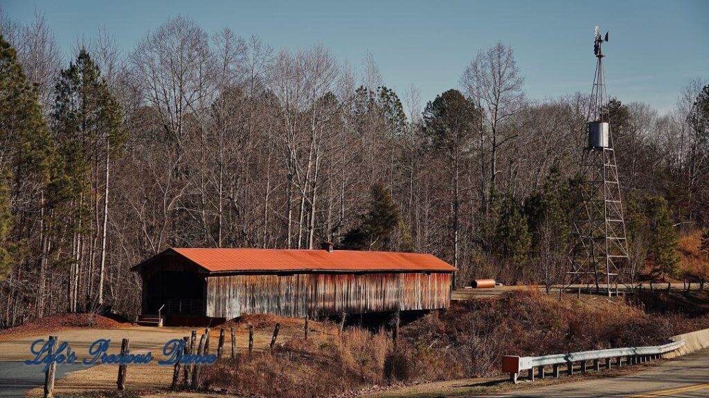 Landscape view of Ole Gilliam Covered Bridge with the windmill towering above.