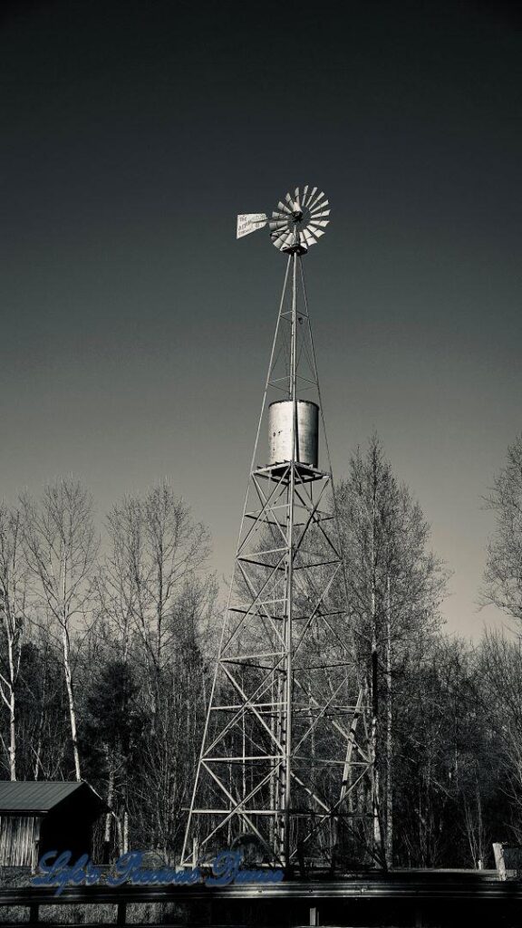 BLack and white of an old windmill and water tank.