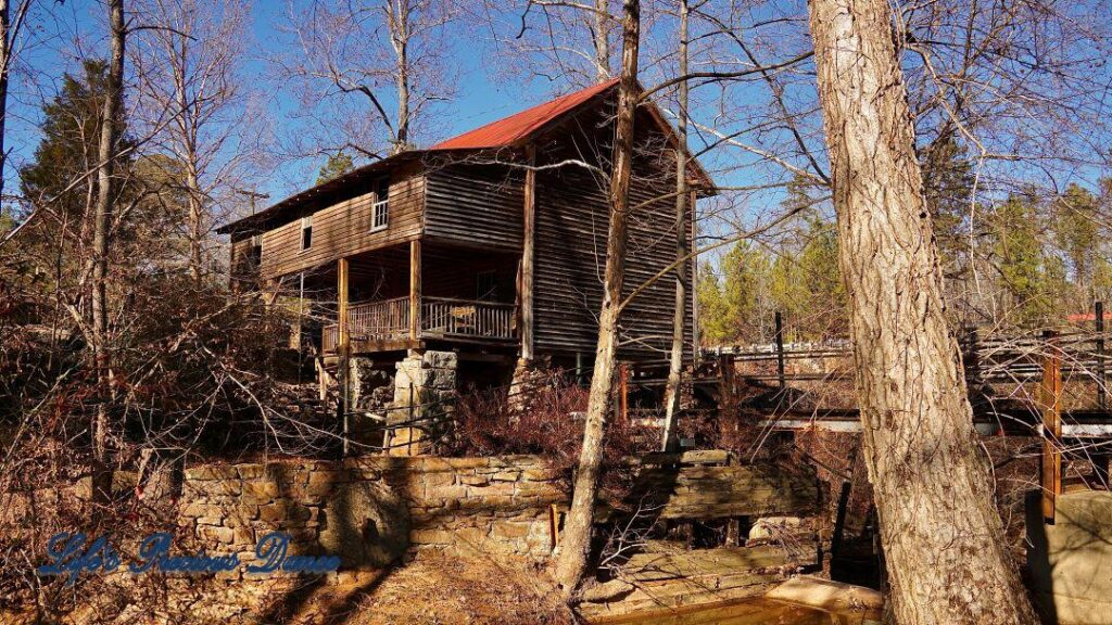 Rear view of Ole Gilliam MIll towering above the creek, amongst trees