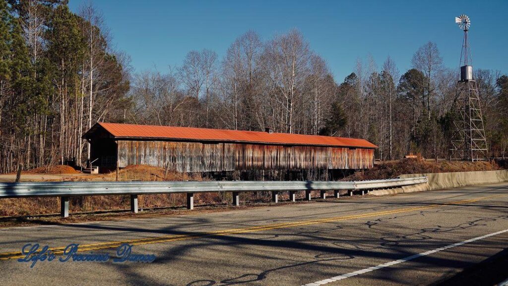 Landscape view of Ole Gilliam Covered Bridge with the windmill towering above.