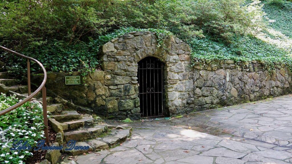 The Spring House at Falls Park. Stone arch with a wrought iron gate.