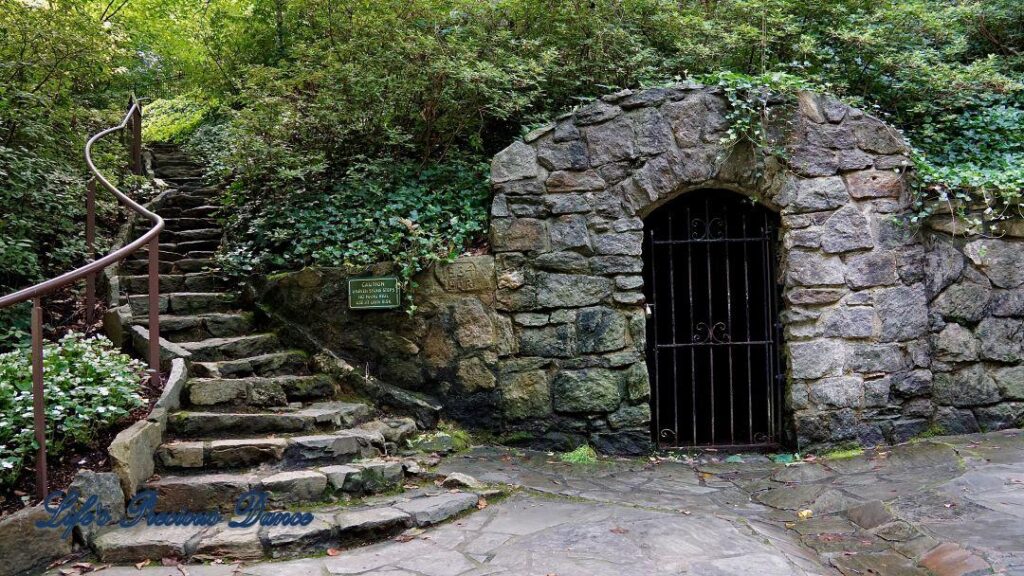 The Spring House at Falls Park. Stone arch with a wrought iron gate.