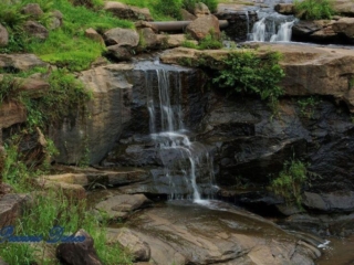 Multi level waterfall spilling over rocks into the river below.