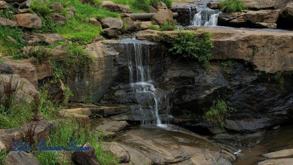 Multi level waterfall spilling over rocks into the river below.