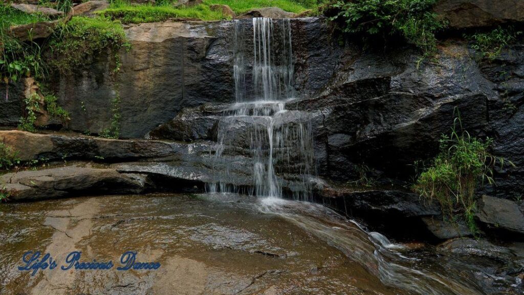 Waterfall spilling over rocks into the river.