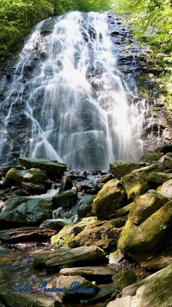 Crabtree Falls cascading down rockface into a pool of water. Rocks in foreground.