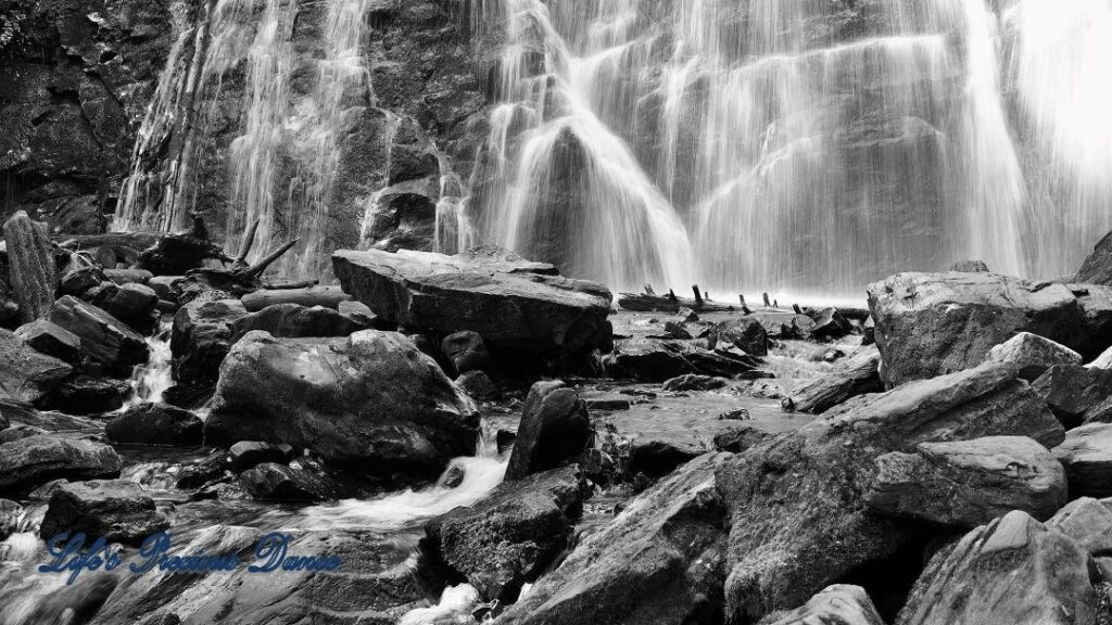 Black and white of Crabtree Falls pouring down rockface into pool of water below.