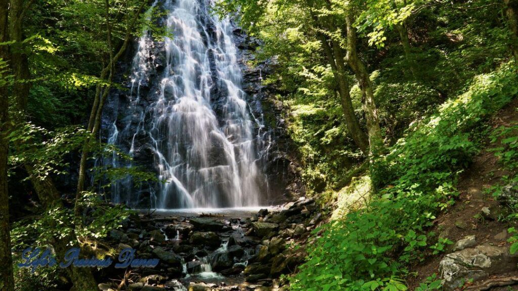 Crabtree Falls spilling down a rockface into mountain stream below.