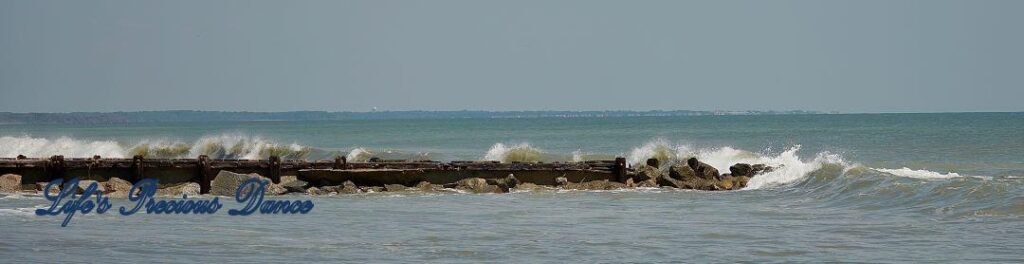 Panoramic of waves crashing on a rock barrier at Edisto Beach