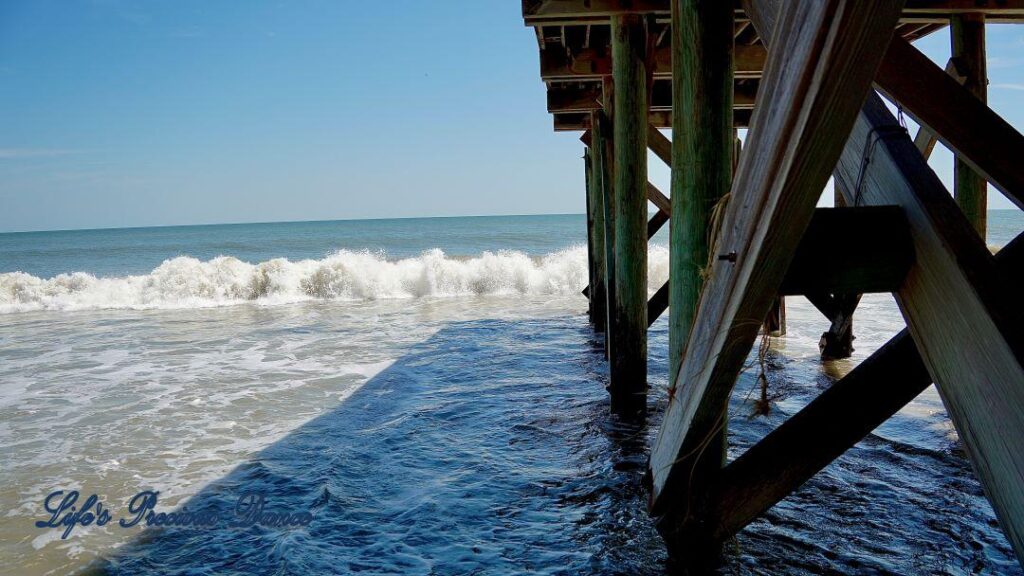 SIde view of waves crashing into the pier at Edisto Beach.