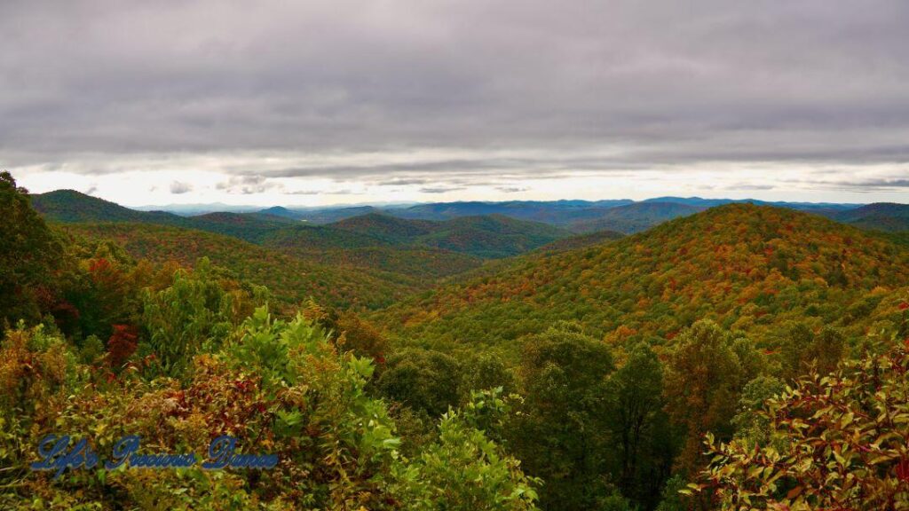 Landscape view of the colorful trees of the Blue Ridge Mountains. Overcast skies overhead.