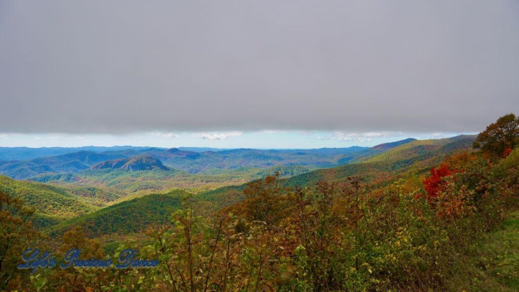 Landscape view of the colorful trees of the Blue Ridge Mountains. Overcast skies overhead.