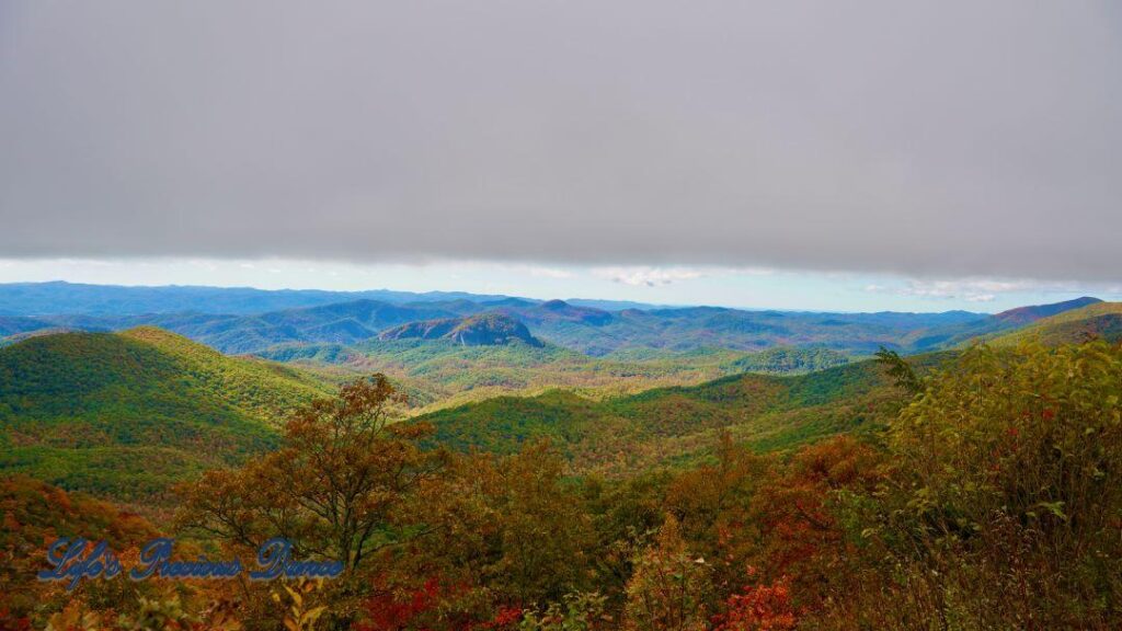 Landscape view of the colorful trees of the Blue Ridge Mountains. Overcast skies overhead.