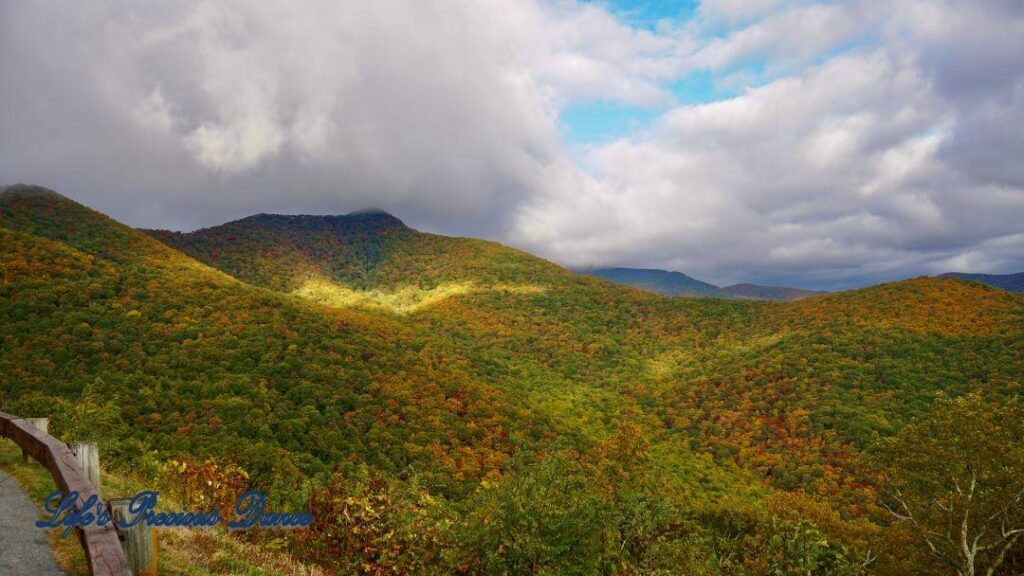 Landscape view of the colorful trees of the Blue Ridge Mountains. Passing clouds against a Carolina blue sky.