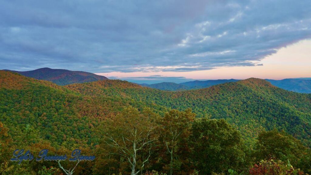 Landscape view of the colorful trees of the Blue Ridge Mountains at dusk. Cloudy skies above.