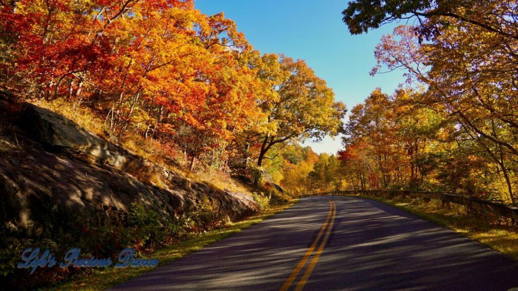 Blue Ridge Parkway surrounded by colorful trees and mountain.