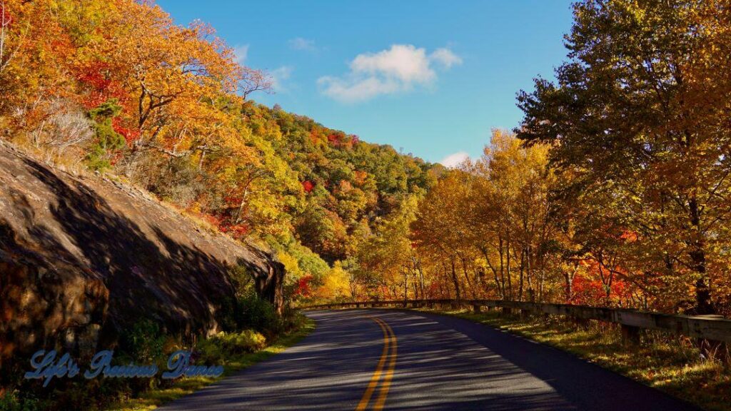 Blue Ridge Parkway surrounded by colorful trees and mountain.