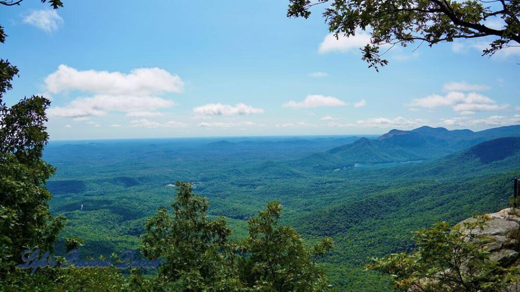 Landscape view from Caesar&#039;s Head looking down into forest valley below. Lake off to the right, clouds high above.