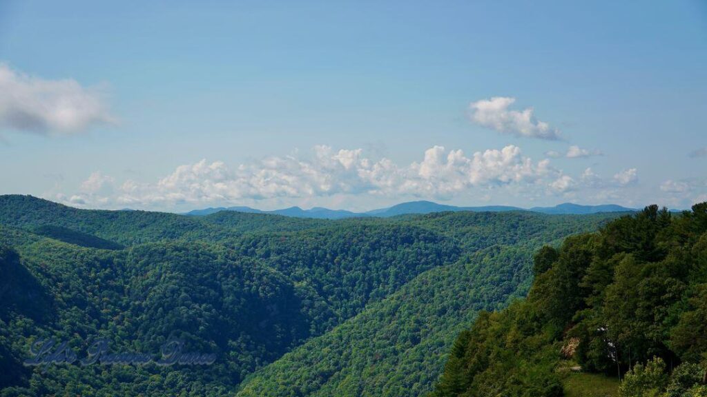 Landscape view of mountain ranges from Caesar&#039;s Head. Clouds drifting up above.