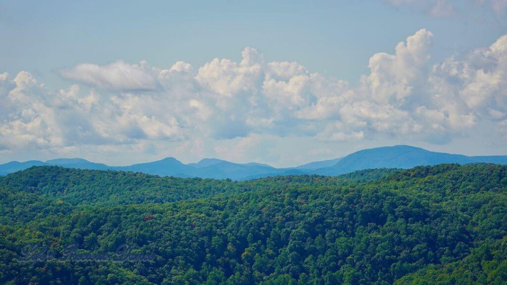 Landscape view of mountain ranges slightly covered in fog, from Caesar&#039;s Head. Clouds drifting up above.