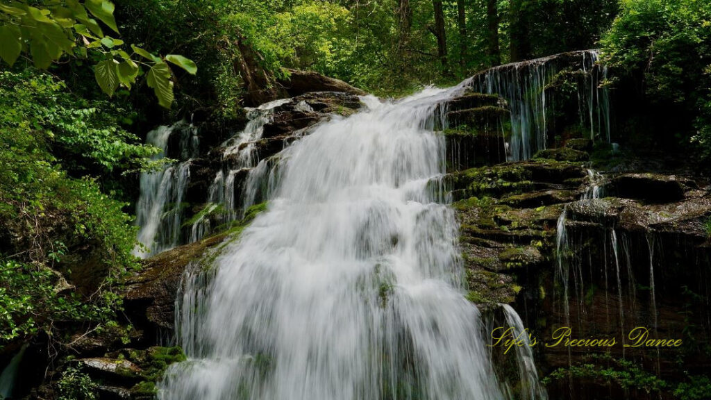 Close up of the top of Long Creek Falls spilling over moss covered rocks.