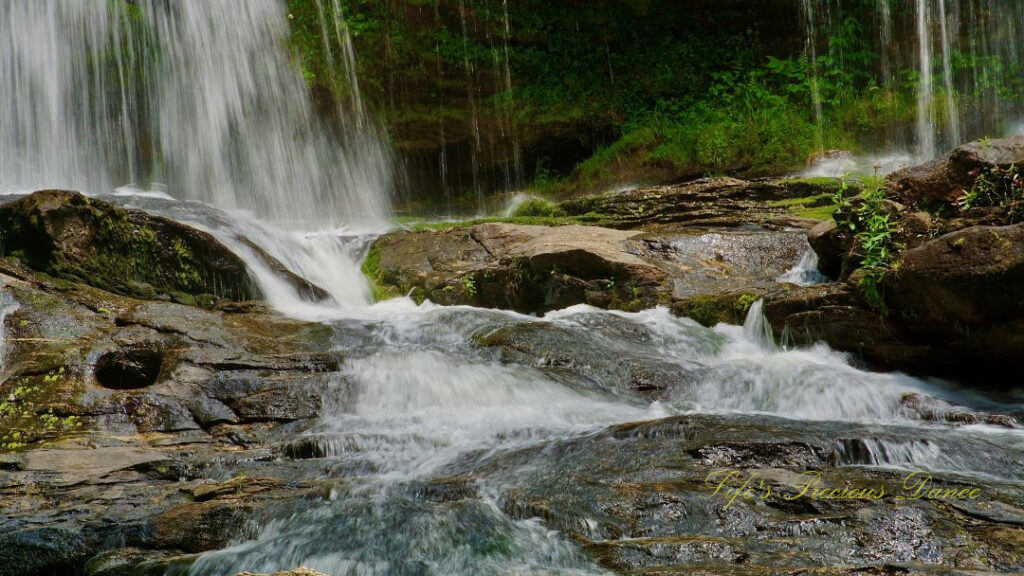 Close up of the base of Long Creek pouring into the creek, over and through the rocks.