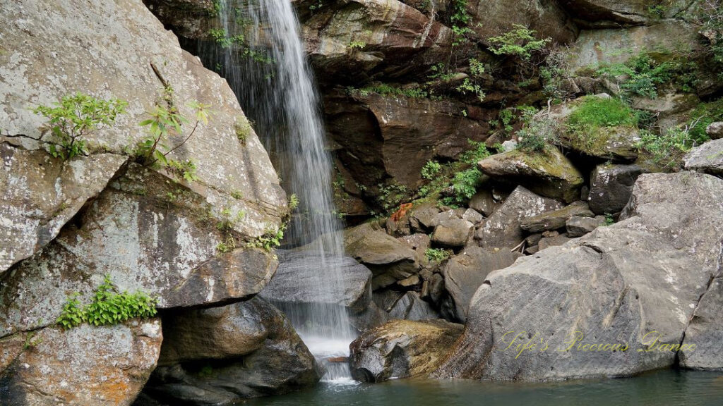 Eagle Falls spilling down the rockface wall, into a pool of water.