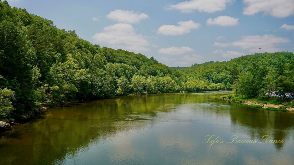 Landscape view from abridge over the Cumberland River. Fluffy clouds and trees reflecting in the water.