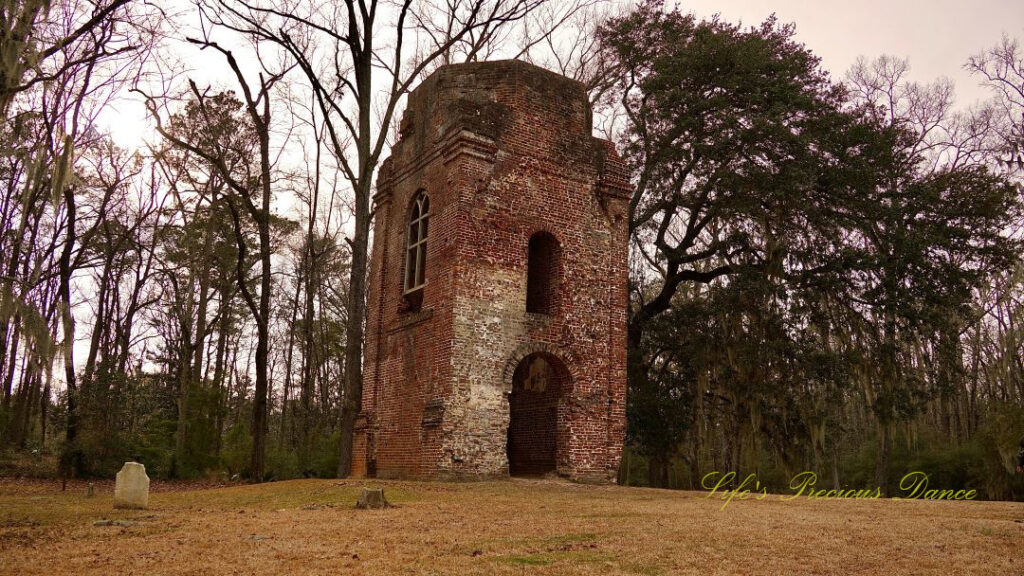 Ground level view, looking upwards, of the bell tower ruins at Colonial Dorchester Historic Site. A lone tombstone sits to the right.