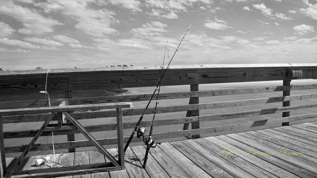 Black and white of fishing poles leaning on a pier at Hunting Island State Park.