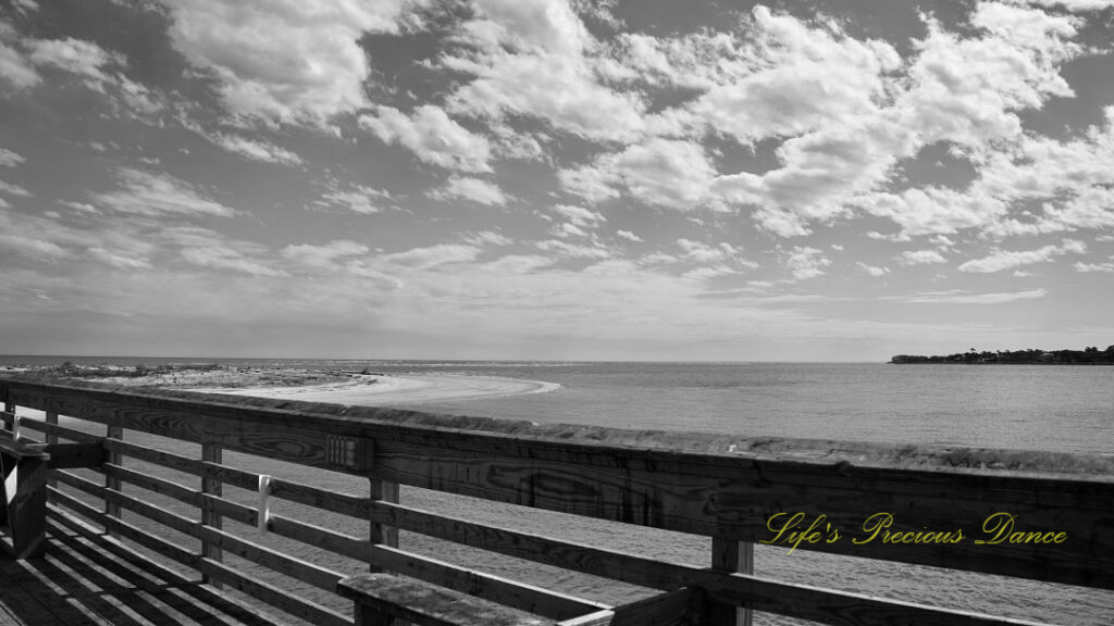 Black and white view of a pier and clouds above the atlantic ocean at Hunting Island State Park.