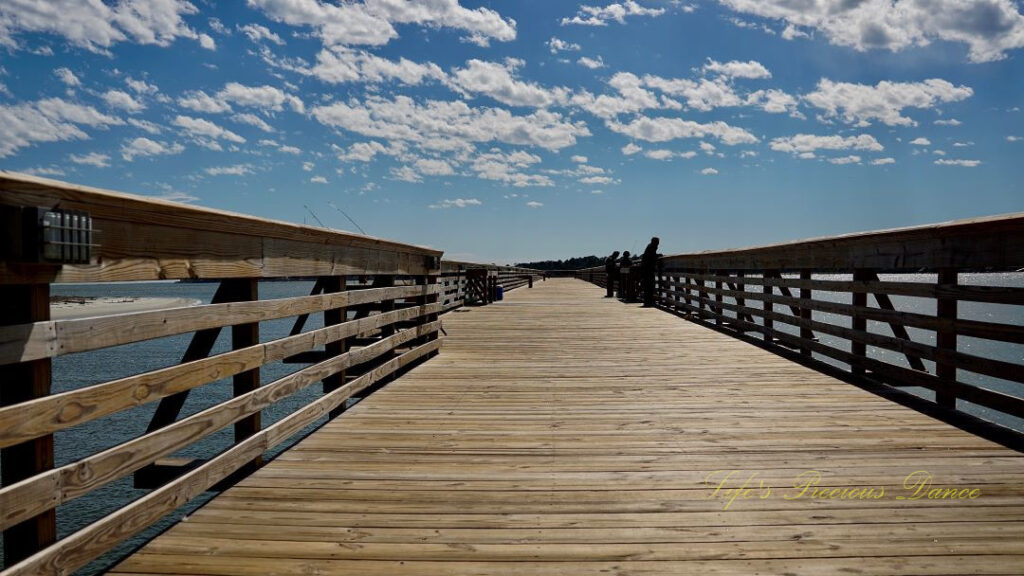 Ground level view of people fishing from the pier at Hunting Island State Park.