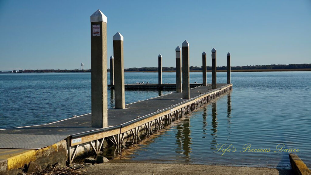 Pier reflecting in the Beaufort River at Sands Beach. A water tower in the background.