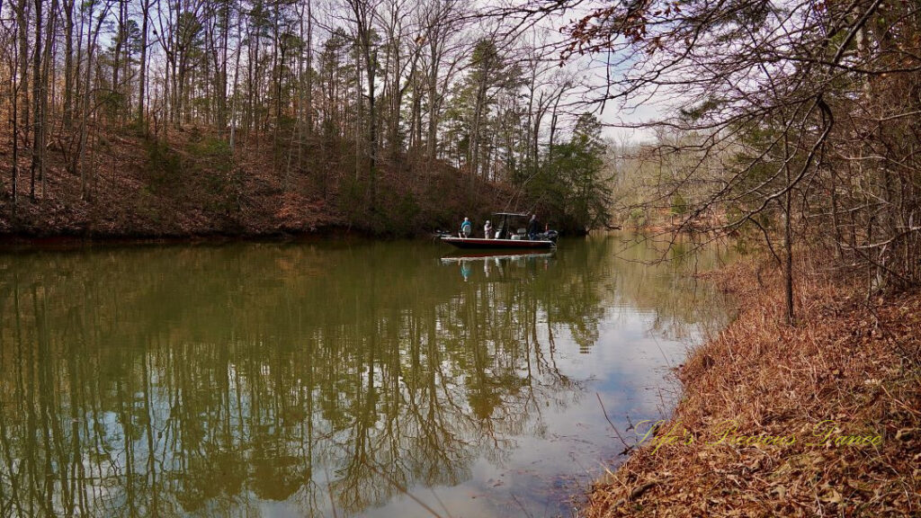 Fisherman on a boat, reflecting in the water at Lake Hartwell.