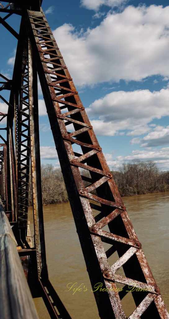 Rusted metal support beam of an old train trestle.