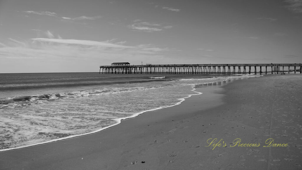 Black and white of the Myrtle Beach pier stretching out into the ocean.