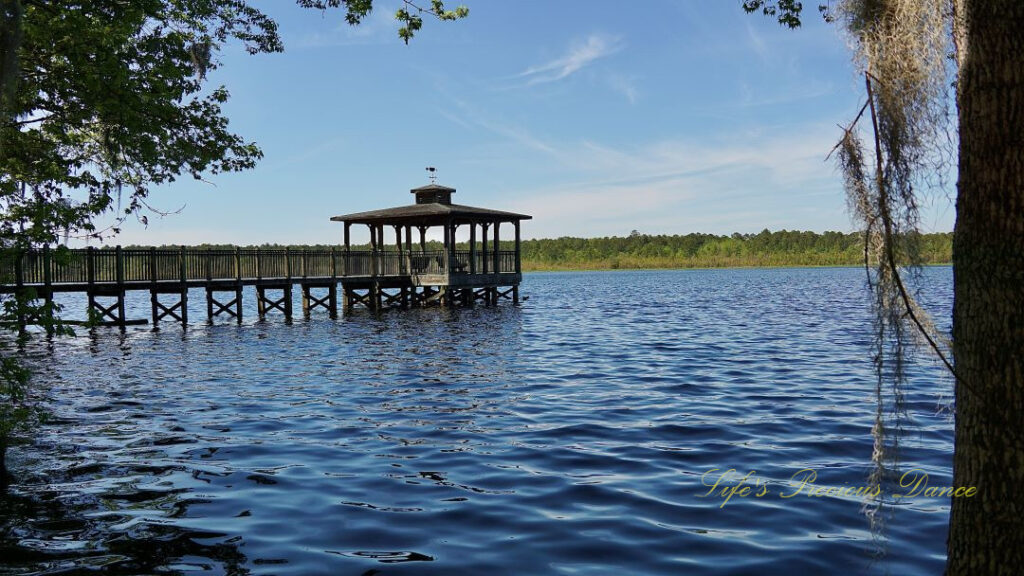 Fishing pier with a gazebo stretching out over Lake Warren. Spanish moss hanging to the right.